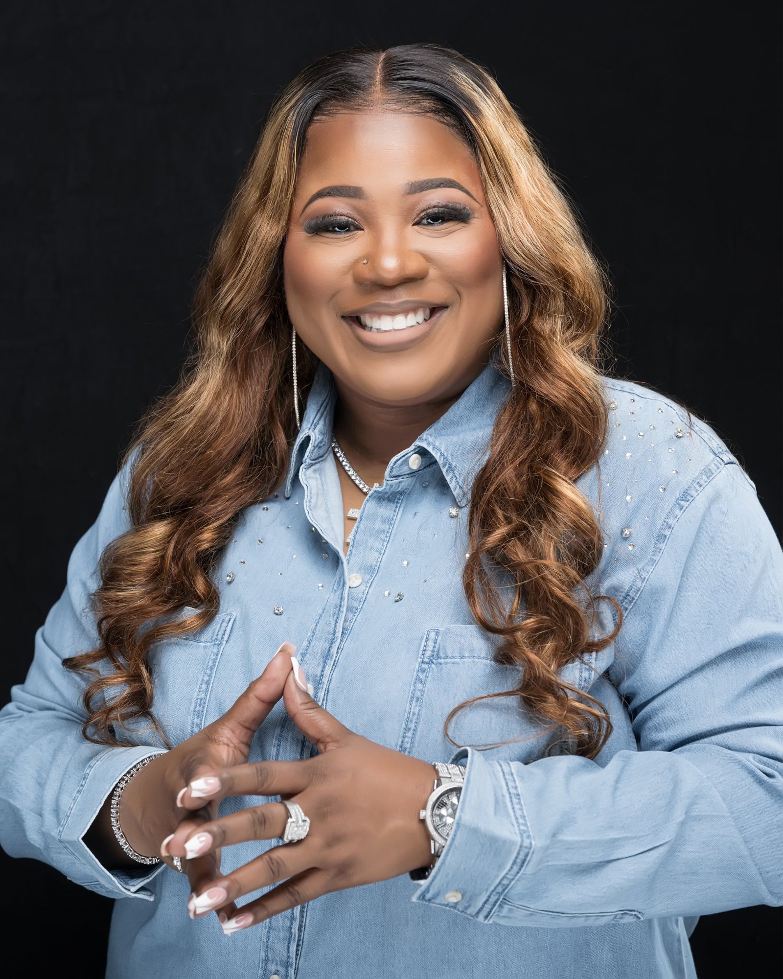 Jacquell The Apostle smiling in a denim shirt