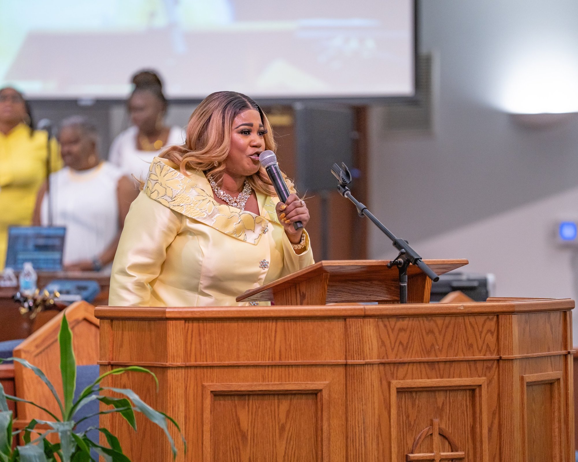 Jacquell The Apostle speaking at a pulpit with a handheld microphone